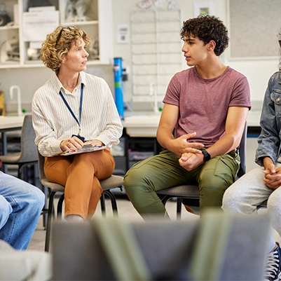 Adult woman facing a young adult male in a support group.