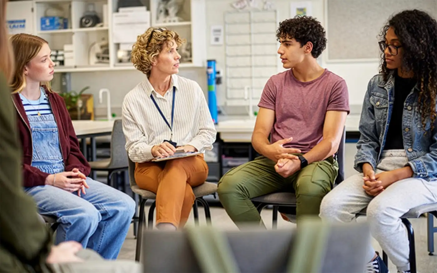A female counselor listens to a young man in a support group.
