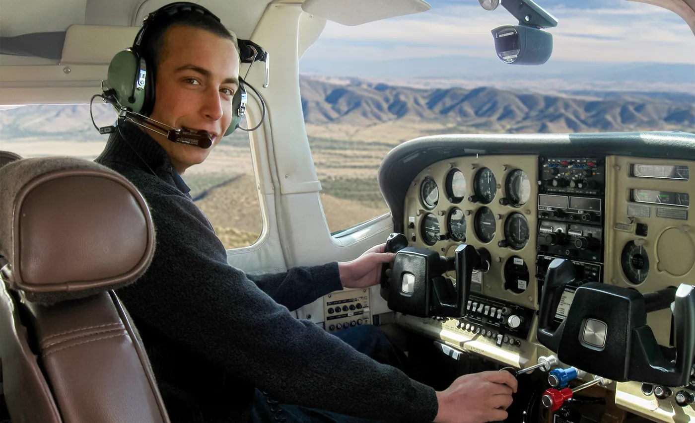 Young man at the flight controls of a private plane.