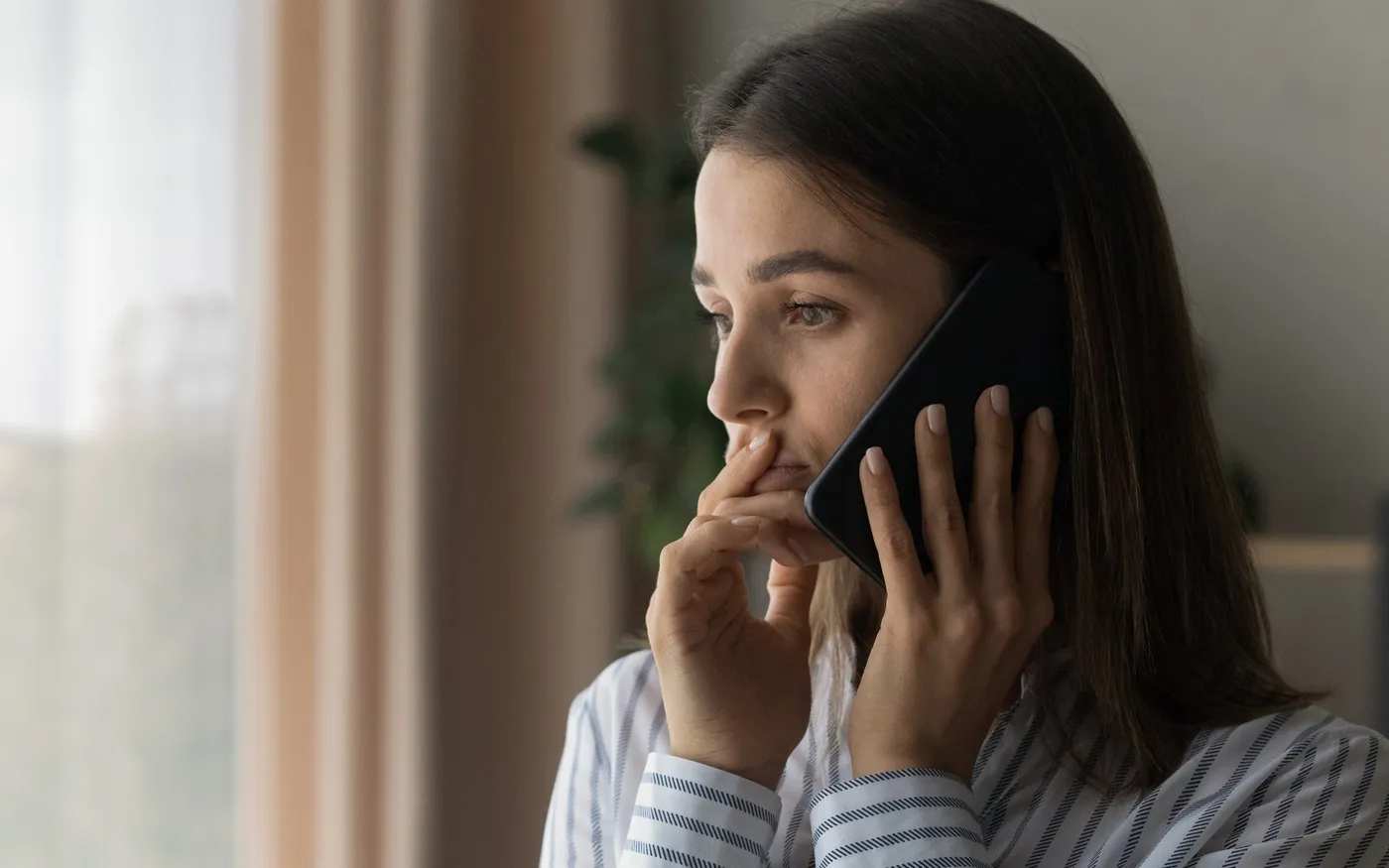 A woman with a worried expression on a cell phone.