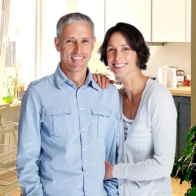 Middle-aged couple at home with a kitchen in the backgound.